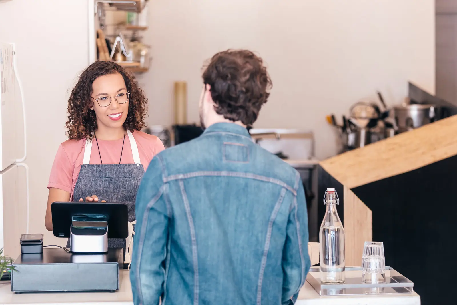 A café worker talking to a customer at the till