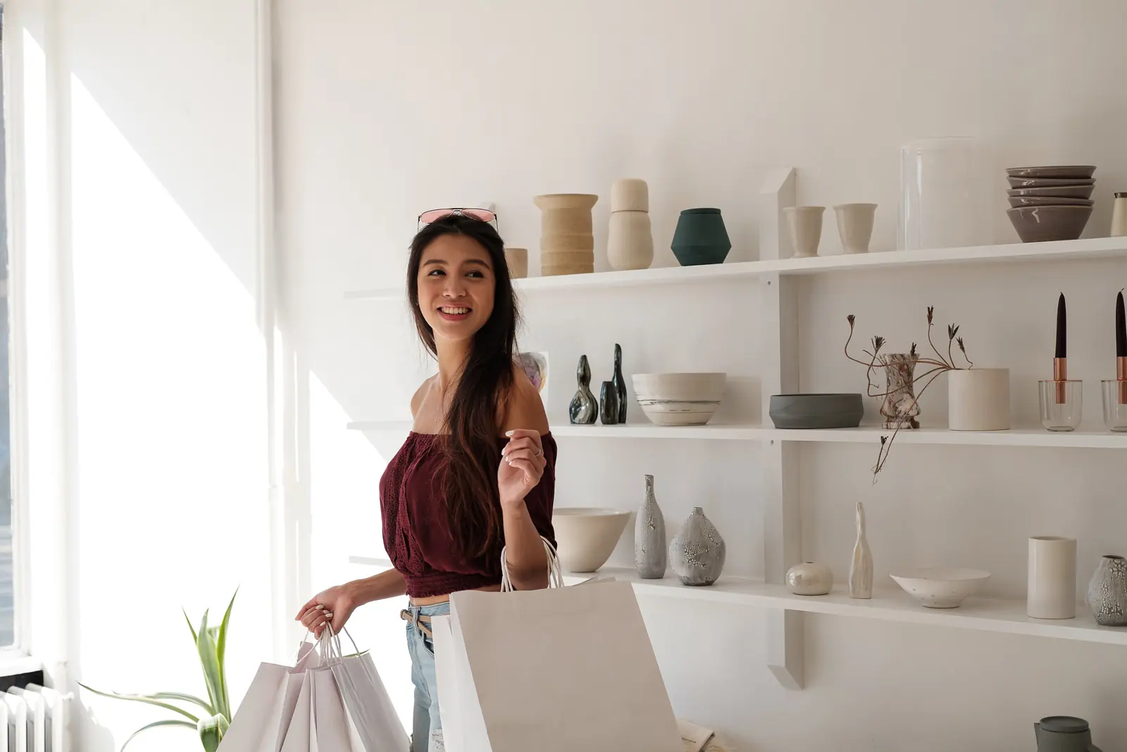 A happy customer leaving a shop with her bags